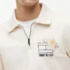 Camisola polo com fecho de correr de um quarto e logótipo floral Camisola polo com fecho de correr de um quarto e logótipo floral